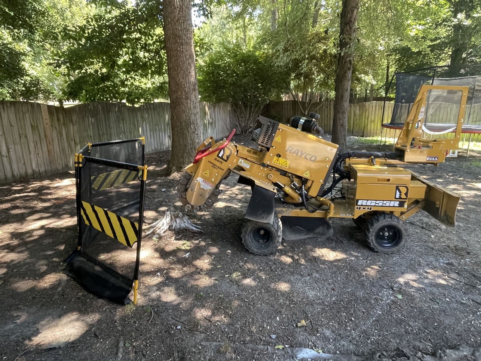 Stump grinder removing a tree stump below grade for lawn restoration in Central Virginia.